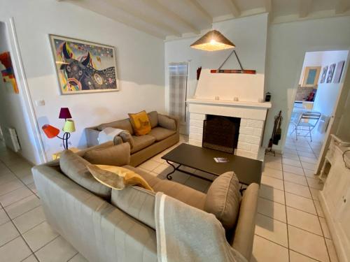 un salon avec un canapé et une cheminée dans l'établissement Welcoming house in Cap Ferret close to the beach, Garden, Terrace, Wifi and TV, à Lège-Cap-Ferret