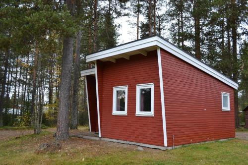 a small red building with two windows in a forest at Doro Camp Lapland in Dorotea