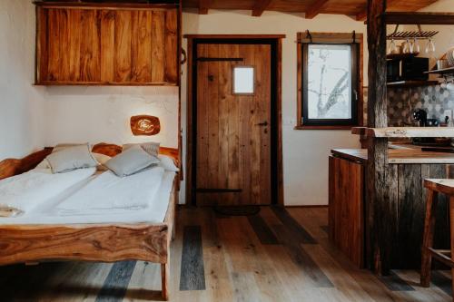 1 dormitorio con 1 cama y suelo de madera en Treehouse Drevesna hiška Štrkovo gnezdo Ranč Jureš, en Ljutomer