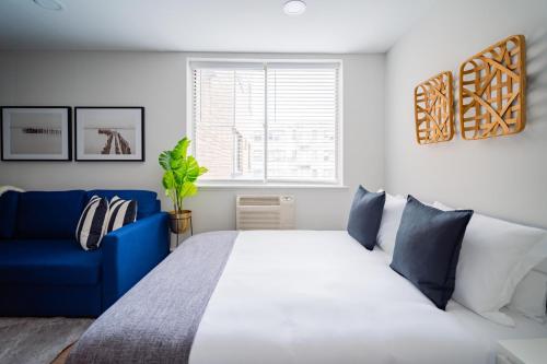 a bedroom with a large bed and a blue couch at Comfy and Complete Studio Apt near Boystown - Oakdale 317 rep in Chicago