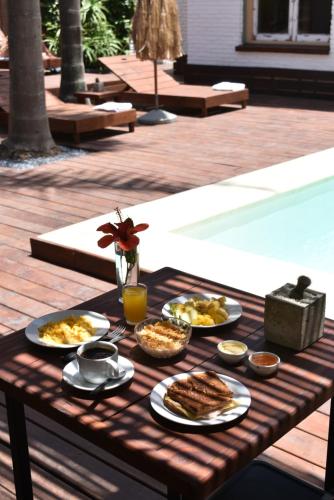 a table with plates of food and drinks on it at TAS D VIAJE Suites - Hostel Boutique in Punta del Este