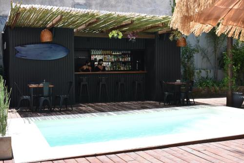 een restaurant met een bar en een zwembad bij TAS D VIAJE Suites - Hostel Boutique in Punta del Este