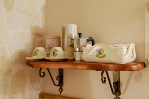 a shelf with a coffee maker and cups on it at B&B Magnolia Centro Storico Grottaglie in Grottaglie