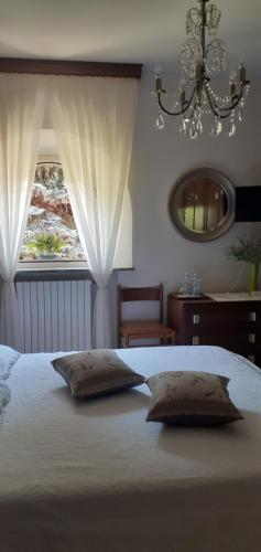 a bed with two pillows in a bedroom with a window at A casa di Lara in Beura