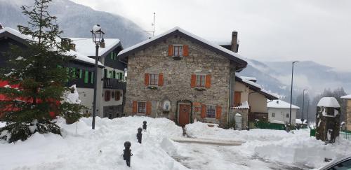 a building covered in snow in front at Casa all’antica fontana in Sùtrio