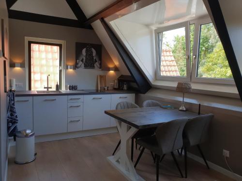 een keuken met een tafel en stoelen en een raam bij Bela Vista in Burgh Haamstede