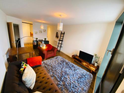 a living room with a couch and a red chair at Stewart St James Walk Apartment in Cheltenham