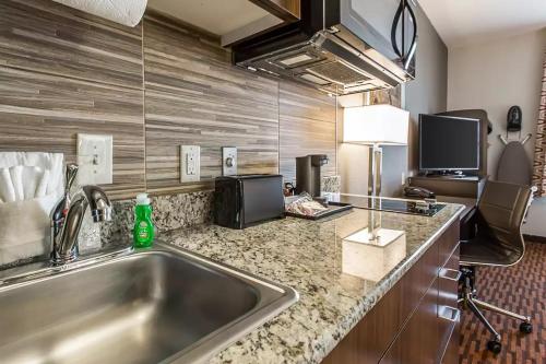 a kitchen with a sink and a counter top at Suburban Studios Midland I-20 in Midland