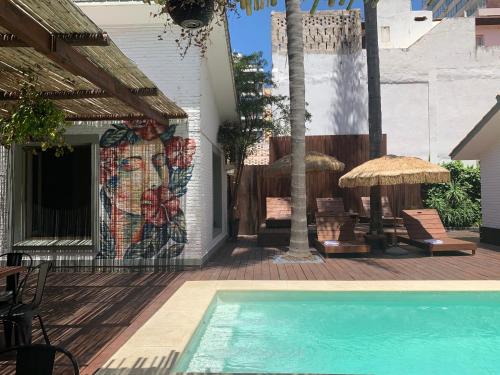 un mural en el lado de una casa con piscina en TAS D VIAJE Suites - Hostel Boutique, en Punta del Este