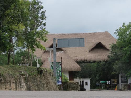 a sign in front of a thatched building at Cabañas Calakmul in Conhuas