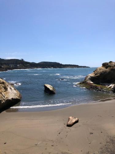 a beach with two large rocks in the water at Inn at Arch Rock in Depoe Bay