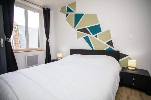 a bedroom with a white bed and a window at Le ptit coin de la Baie in Fort-Mahon-Plage