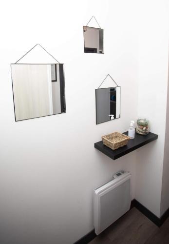 two mirrors above a toilet in a bathroom at Le ptit coin de la Baie in Fort-Mahon-Plage