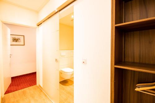 a small bathroom with a toilet and a closet at Hotel Stadtschänke in Walsrode