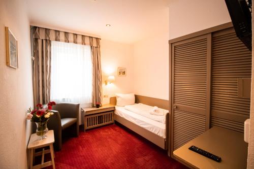 a hotel room with a bed and a window at Hotel Stadtschänke in Walsrode