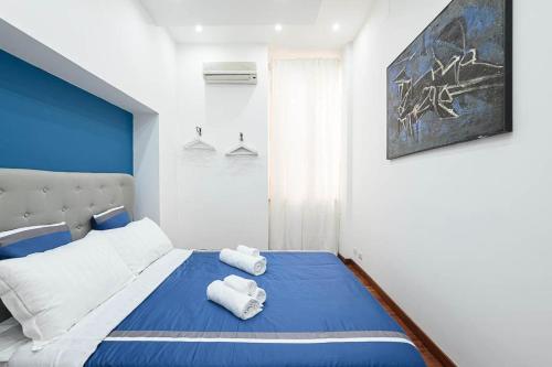 una camera da letto con un letto blu e bianco con asciugamani di Design Suite Trevi Fountain a Roma