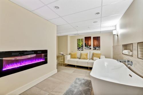 a bathroom with a tub and a tv on the wall at Oceanfront Suites at Cowichan Bay in Cowichan Bay