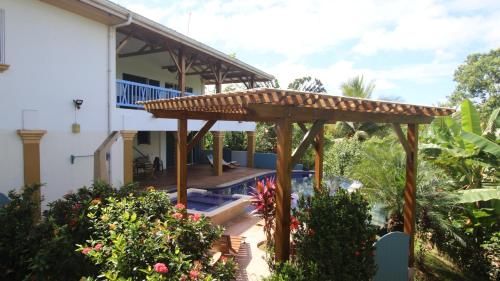 a patio with a pergola in front of a house at TREEHOUSE PILON PAVONES in Pavones