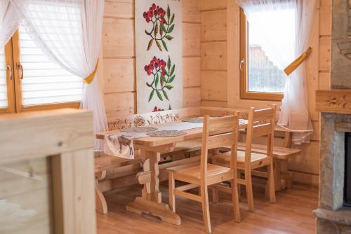 Domki Krupa Chochołów في شوشولو: غرفة طعام مع طاولة وكراسي ومدفأة