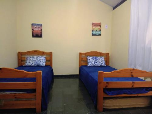 カボ・フリオにあるCasa em condomínio - Praia do Peróのブルーシーツ付きの客室内のベッド2台