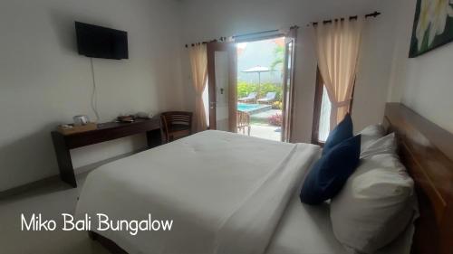 A bed or beds in a room at Miko Bali Bungalow