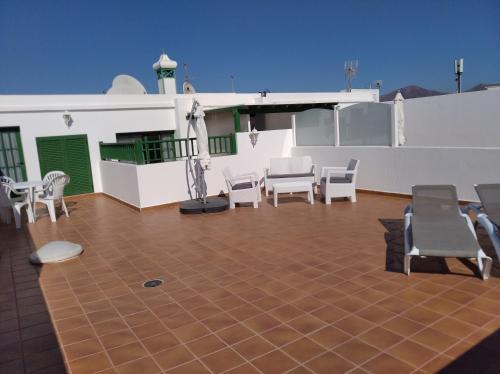 a patio with chairs and tables on a building at Apartamentos Casa Cipri in Playa Blanca