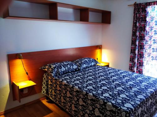 um quarto com uma cama com um edredão azul em La Comarca em Colônia do Sacramento