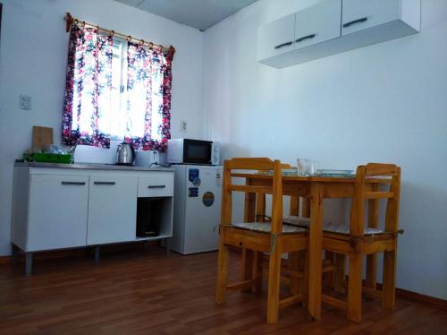 a small kitchen with a table and a refrigerator at La Comarca in Colonia del Sacramento