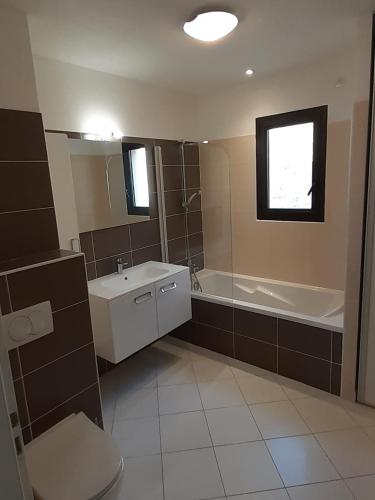 une salle de bain avec un lavabo, une baignoire et des toilettes dans l'établissement Vaste appartement 3 chambres - Vue exceptionnelle, à Chorges