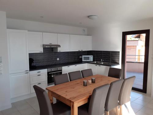 a kitchen with a wooden table and some chairs at Vaste appartement 3 chambres - Vue exceptionnelle in Chorges