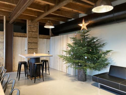 un sapin de Noël dans une pièce avec une table et des chaises dans l'établissement Gîte L'Atelier de Tournerie, à Montigny-sur-lʼAin