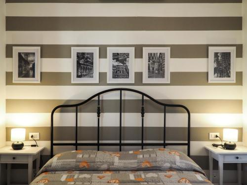 a bedroom with striped walls and a bed with two tables at Amba Alagi Apartment in Genoa