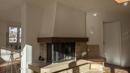 a living room with a brick fireplace with a tv at Ferienwohnung Parsennblick mit Dachterrasse in Davos