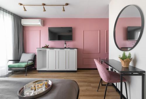 a bedroom with pink walls and a mirror at Dizengoff Garden Hotel in Tel Aviv