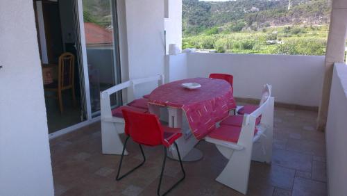 a table and chairs on a balcony with a view at Apartman Somun in Lopar