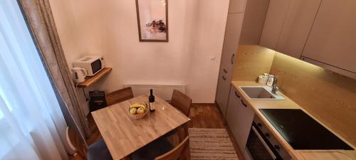 a small kitchen with a table and a sink at SL Apartment Bjelasnica in Bjelašnica