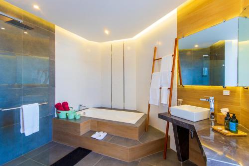 a bathroom with a bath tub and a sink at Hotel Acacia in Puerto Ayora