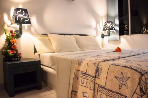 1 dormitorio con 1 cama con 2 lámparas en una mesa en Coral Clubes Acapulco, en Acapulco