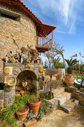 a stone house with a stone fireplace and potted plants at Traditional Windmill-Milos in Kroústas