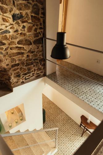 a room with a stone wall and a black lamp at Azeite de Marvão, Olivoturismo casa Venda do Lagar in Marvão