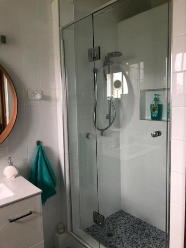y baño con ducha y puerta de cristal. en Fi's Beach House en Port Macquarie