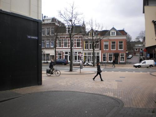 a woman walking down a street in a city at Hostel Pension Tivoli in Groningen