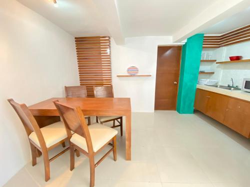 a kitchen and dining room with a wooden table and chairs at Rocamar Hotel Isla Mujeres in Isla Mujeres