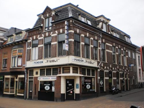 a large brick building on the corner of a street at Hostel Pension Tivoli in Groningen
