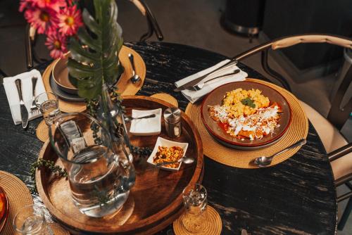 a table with two plates of food and a vase at CASA EMILIA B&B Boutique in Mexico City