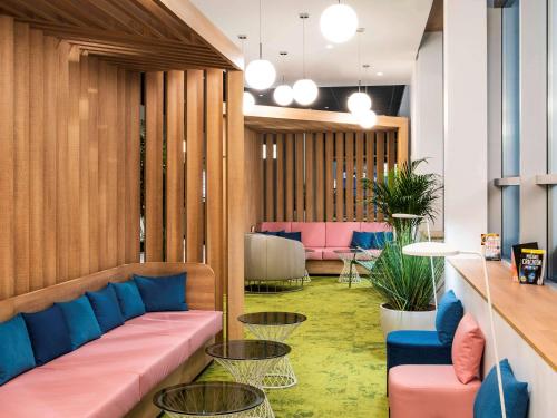 a lobby with a couch and tables and chairs at ibis Paris CDG Airport in Roissy-en-France