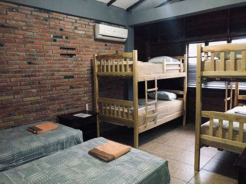 Cette chambre comprend 2 lits superposés et un mur en briques. dans l'établissement Tavarua Hotel, à Montañita