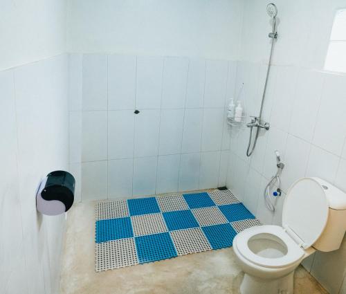 a bathroom with a toilet and a blue and white tile floor at Hotel Gunung Mas Syariah in Diyeng