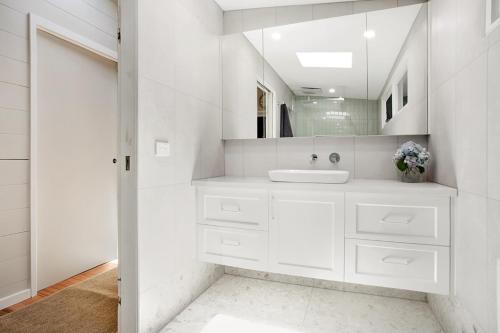 a white bathroom with a sink and a mirror at Bright River Rest in Bright