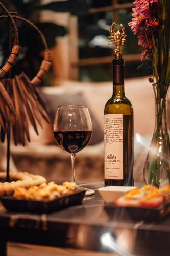 a bottle of wine sitting next to a glass of wine at CASA EMILIA B&B Boutique in Mexico City